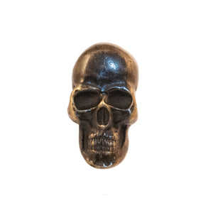 A brass knob shaped like a skull.