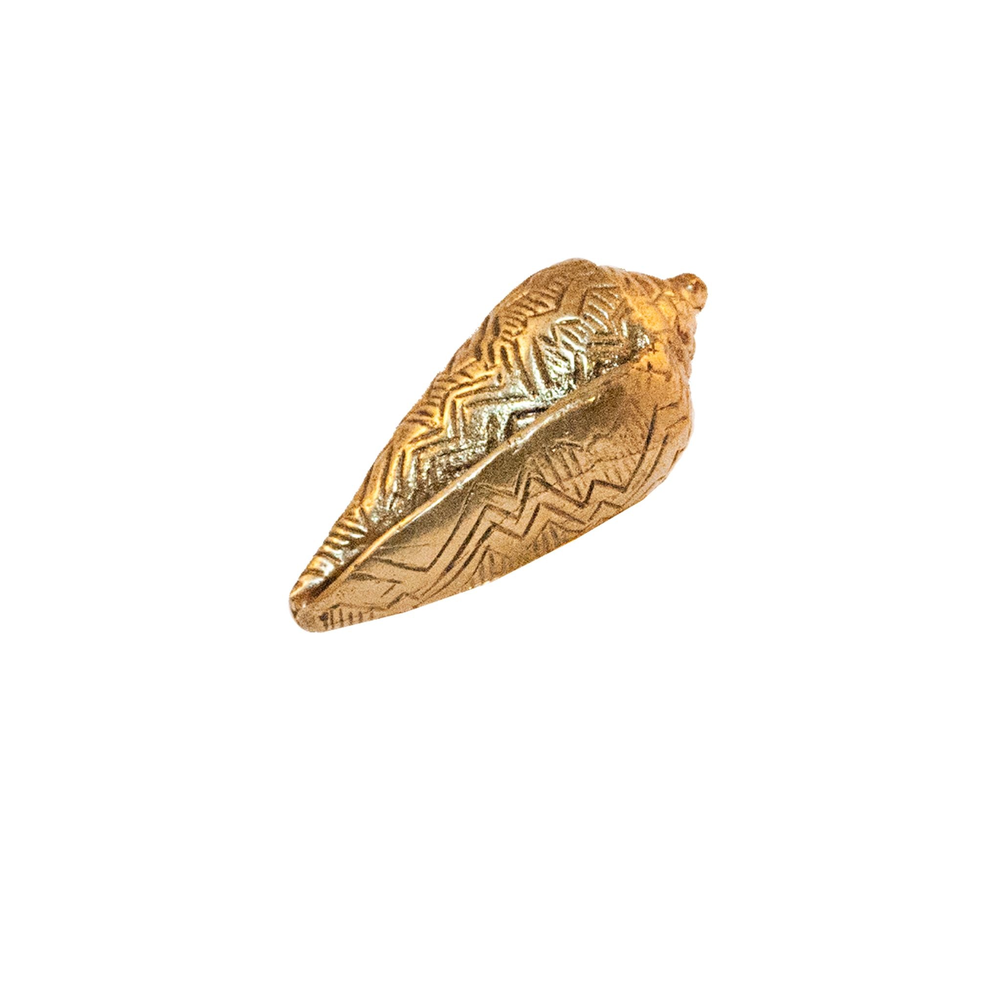 A brass knob shaped like an elongated seashell.