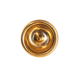 A decorative circular brass knob with a polished finish, featuring intricate detailing around the edges, designed for use on cabinets, drawers, and furniture.