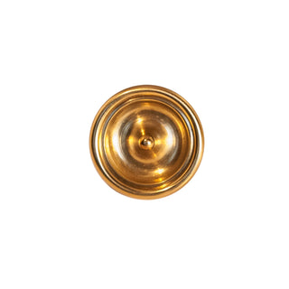 A decorative circular brass knob with a polished finish, featuring intricate detailing around the edges, designed for use on cabinets, drawers, and furniture.