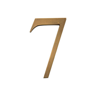 This is a small house number 7, made of solid brass. It features a smooth, polished surface with an elegant and refined finish. The compact size makes it a subtle yet stylish addition to any home exterior. Its durable brass construction ensures long-lasting quality and timeless appeal.