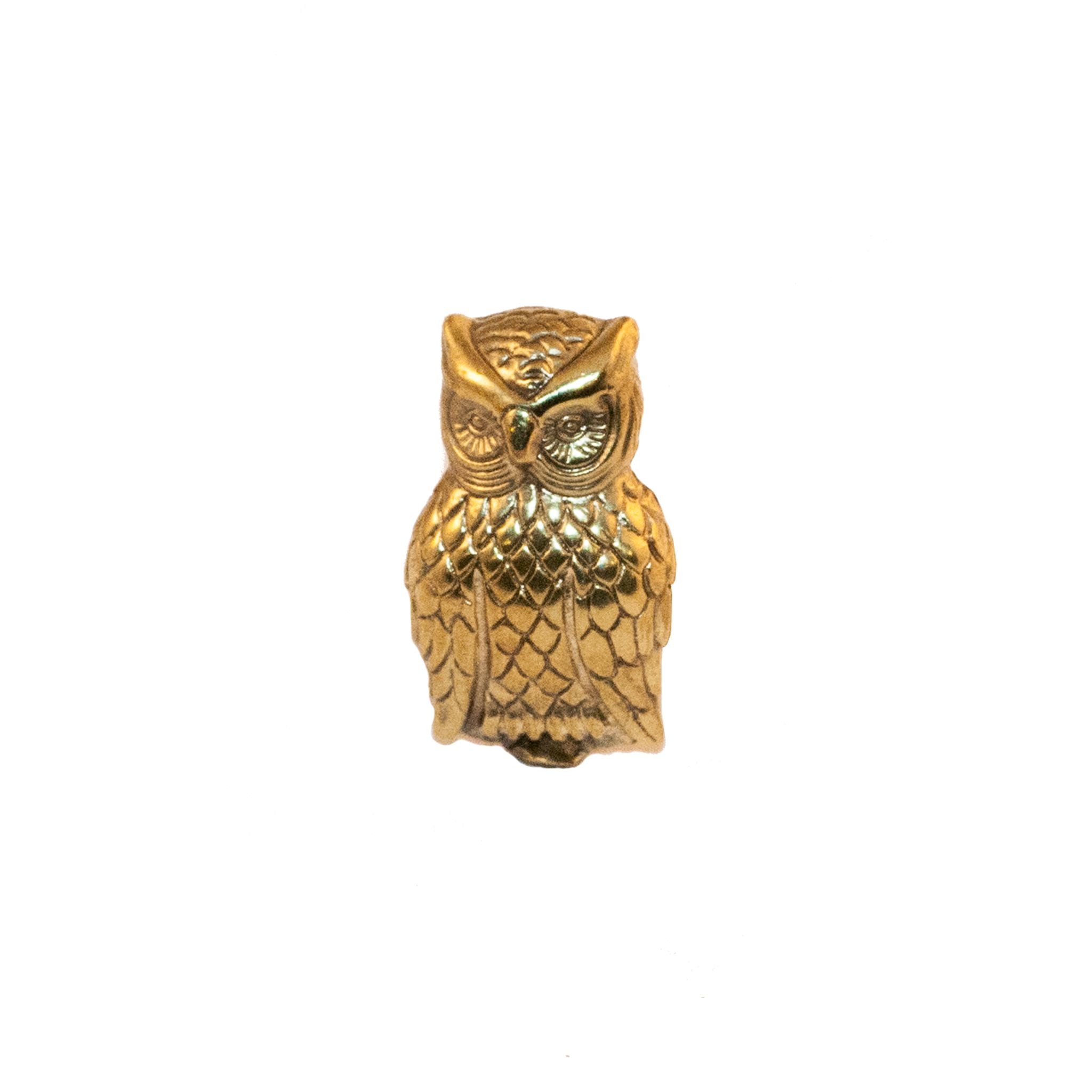 A small brass knob shaped like an owl.