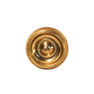 A polished, circular brass knob with intricate decorative patterns, designed for use on cabinets, drawers, and doors.